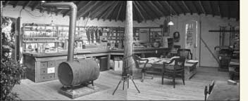 Interior of shop, showing work benches. Stove made from 50-gallon oil drum with cast-iron barrel stove kit.