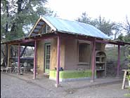 Guest cottage, one of our favorites. Like everything else, still under construction. A variety of clay plasters. Exterior has straw/clay plaster in front and lavender clay finish on wall around window. Bamboo, clay and straw shelves to rear were molded into place. Interior has polished clay walls.