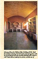 Library of Save the Children Office Building. Vault formed by tensioning carrizo reeds and covering them with an insulating mix of straw and clay, finished with a concrete shell. Book shelves made by the women and kids out of molded straw and clay. Walls are finished with beautiful red clay from nearby colonial town named Alamos.