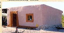 One-room experimental house of straw bales, built for a family using donations put together by folks all over world