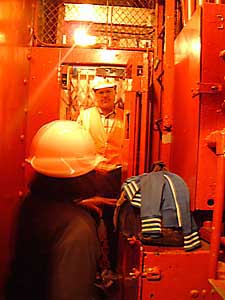 Bob in background, inside elevator, Krystal with hardhat